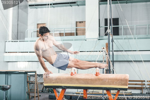 Image of The sportsman during difficult exercise, sports gymnastics