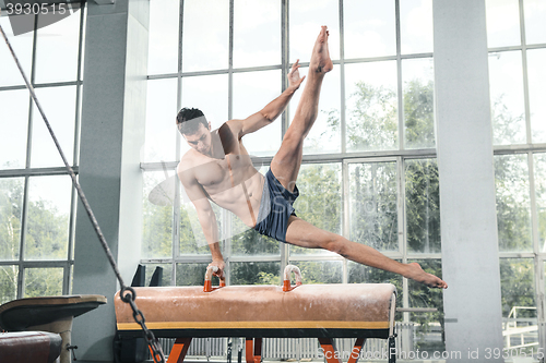 Image of The sportsman during difficult exercise, sports gymnastics