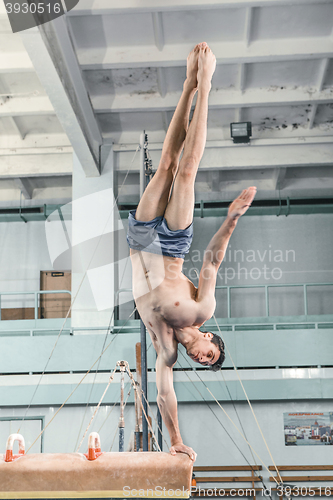 Image of The sportsman during difficult exercise, sports gymnastics