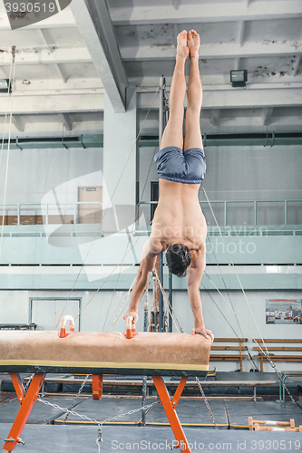 Image of The sportsman during difficult exercise, sports gymnastics