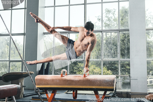 Image of The sportsman during difficult exercise, sports gymnastics