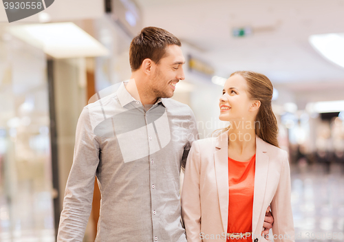 Image of happy young couple with shopping bags in mall