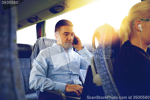 Image of man with smartphone and laptop in travel bus