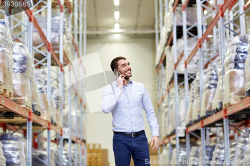 Image of happy man calling on smartphone at warehouse