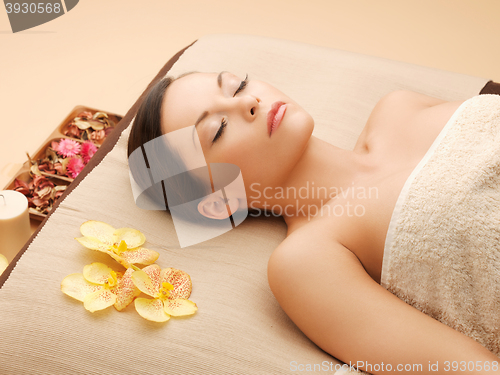 Image of woman in spa salon lying on the massage desk