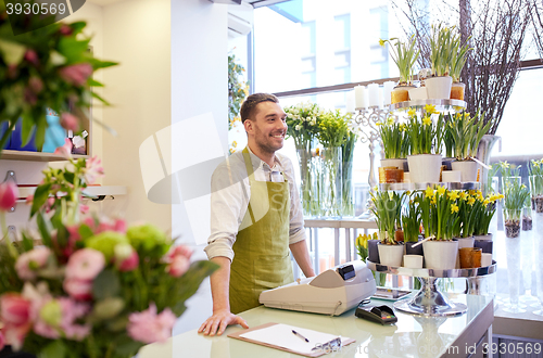 Image of florist man with clipboard at flower shop counter