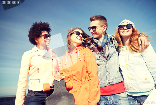 Image of happy teenage friends in shades talking on street