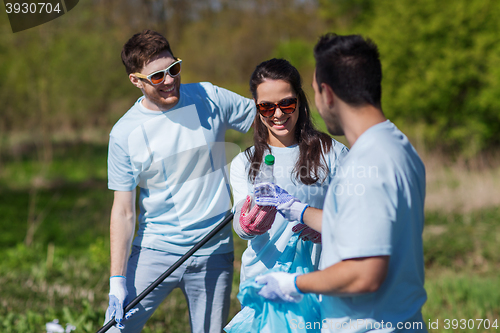 Image of volunteers with garbage bags cleaning park area