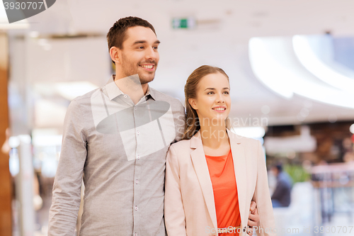 Image of happy young couple with shopping bags in mall