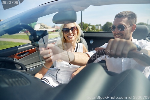 Image of happy couple using gps navigator in cabriolet car