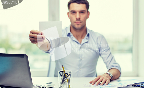 Image of businessman showing blank paper card at office