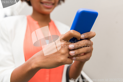 Image of close up of african woman with smartphone in city