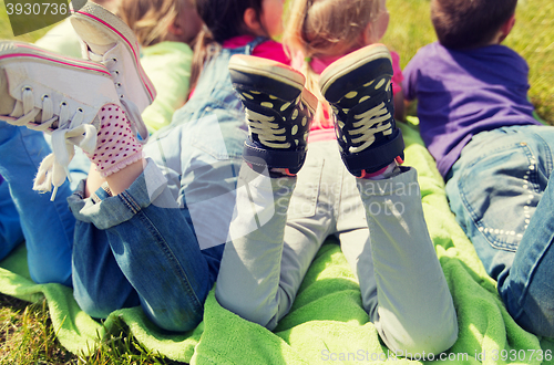 Image of close up of kids lying on picnic blanket outdoors