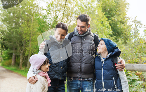 Image of happy family with backpacks hiking