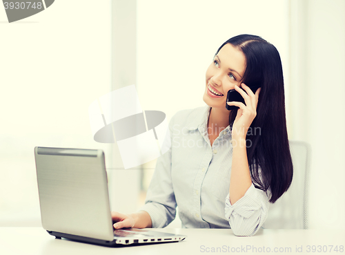 Image of businesswoman with laptop and cell phone