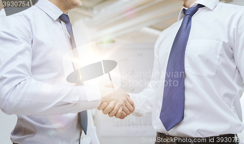 Image of two businessmen shaking hands in office