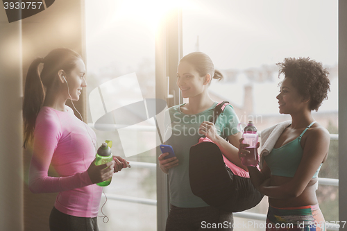 Image of happy women with bottles of water in gym