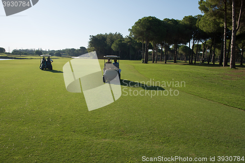 Image of golf players driving cart at course