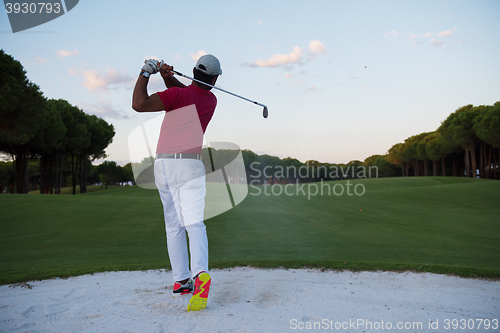 Image of golfer hitting a sand bunker shot on sunset