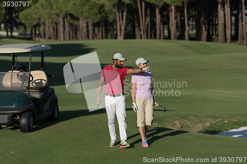 Image of couple walking on golf course