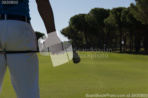 Image of golf player close up hand and driver from back