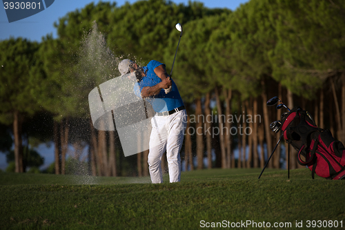 Image of golfer hitting a sand bunker shot on sunset