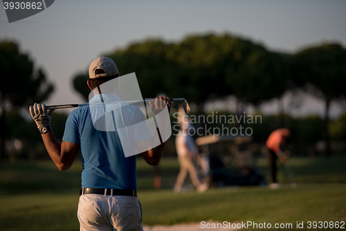 Image of golfer from back at course looking to hole in distance