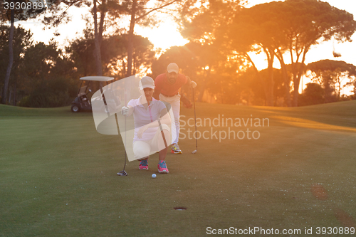 Image of couple on golf course at sunset