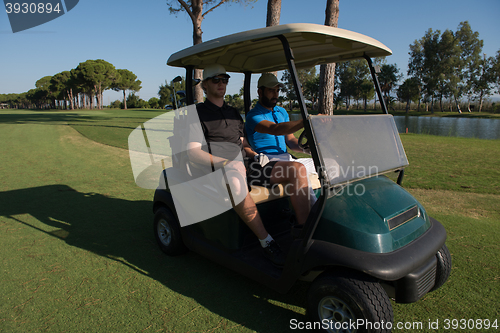 Image of golf players driving cart at course