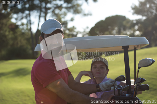 Image of couple in buggy on golf course