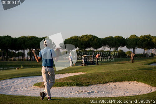 Image of golfer from back at course looking to hole in distance