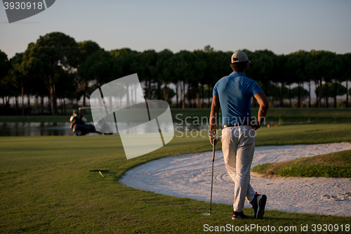 Image of golfer from back at course looking to hole in distance