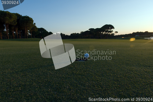 Image of golf ball on edge of  the hole