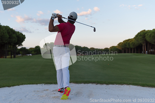 Image of golfer hitting a sand bunker shot on sunset