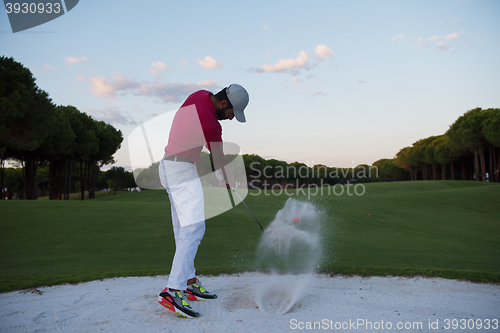 Image of golfer hitting a sand bunker shot on sunset