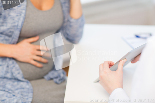 Image of close up of doctor with tablet and pregnant woman
