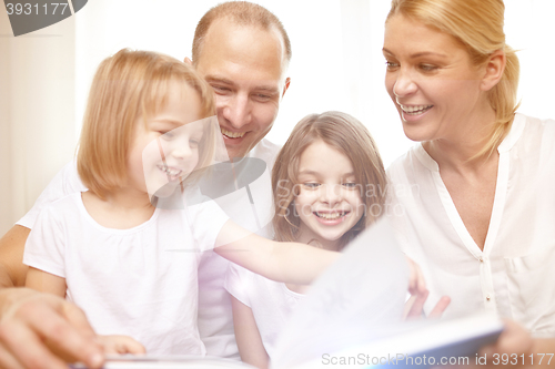 Image of happy family reading book at home