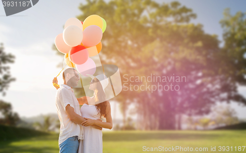 Image of smiling couple with air balloons outdoors