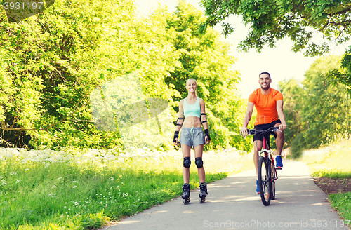 Image of happy couple with rollerskates and bicycle riding