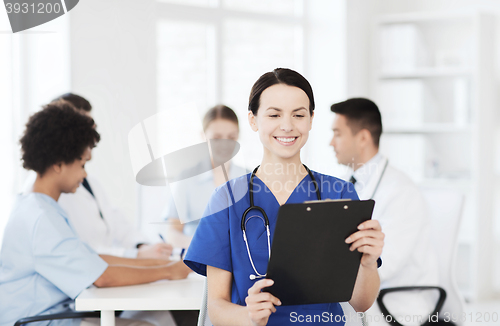 Image of happy doctor over group of medics at hospital