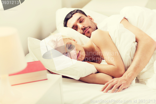 Image of happy couple sleeping in bed at home