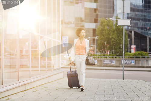 Image of young african woman with travel bag in city