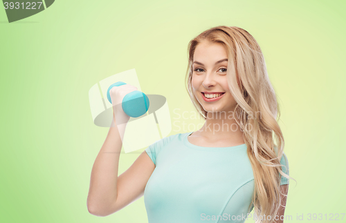 Image of smiling beautiful young sporty woman with dumbbell