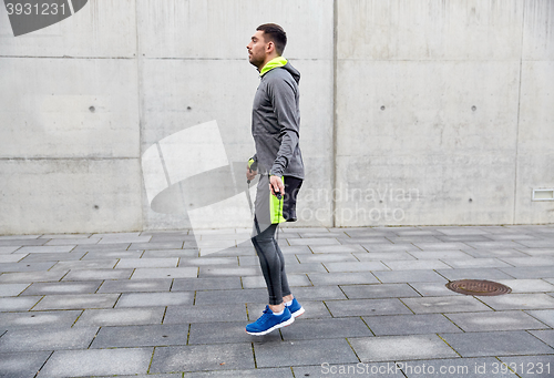 Image of man exercising with jump-rope outdoors