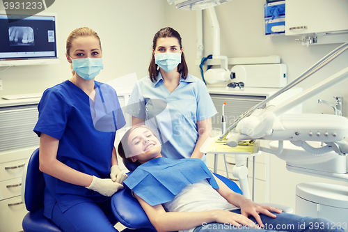 Image of happy female dentist with patient girl at clinic