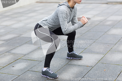 Image of close up of woman doing squats outdoors