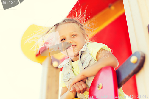 Image of happy little girl climbing on children playground