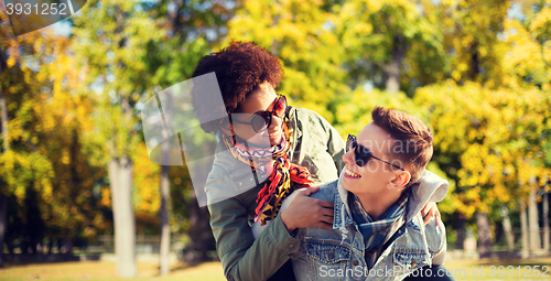 Image of happy teenage couple in shades having fun outdoors