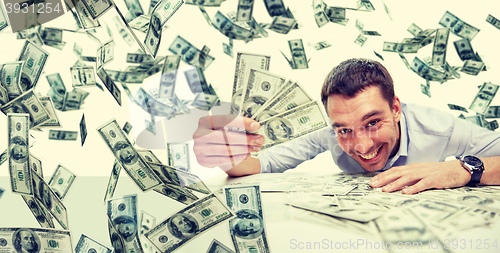 Image of happy businessman with heap of money