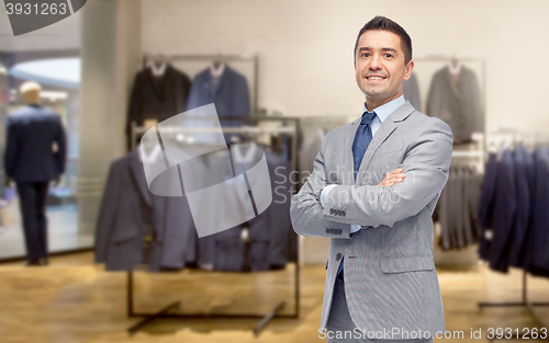 Image of happy businessman in suit over clothing store